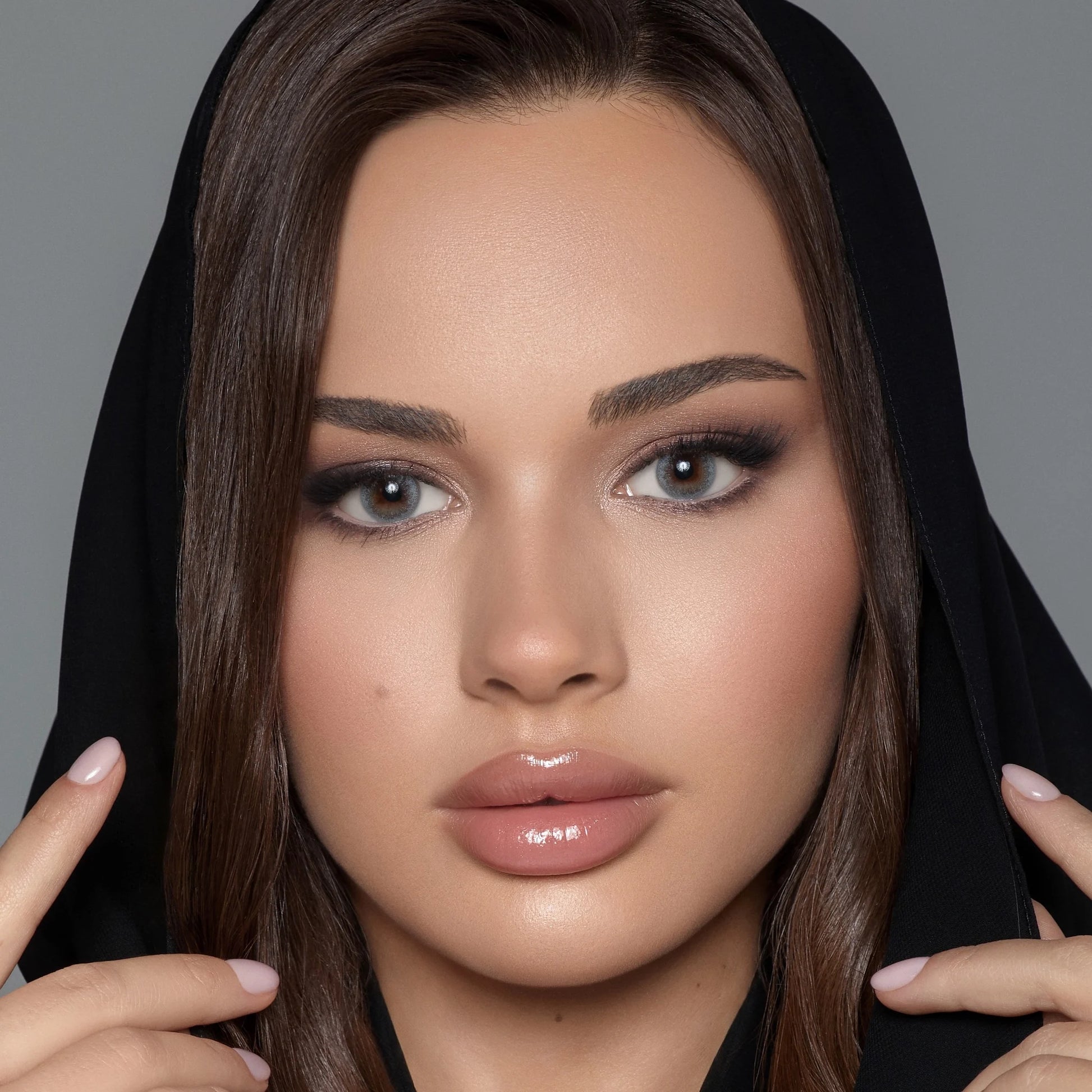 Close-up of a woman with makeup and a black hijab wearing Bella colored contact lenses named Silent Gray